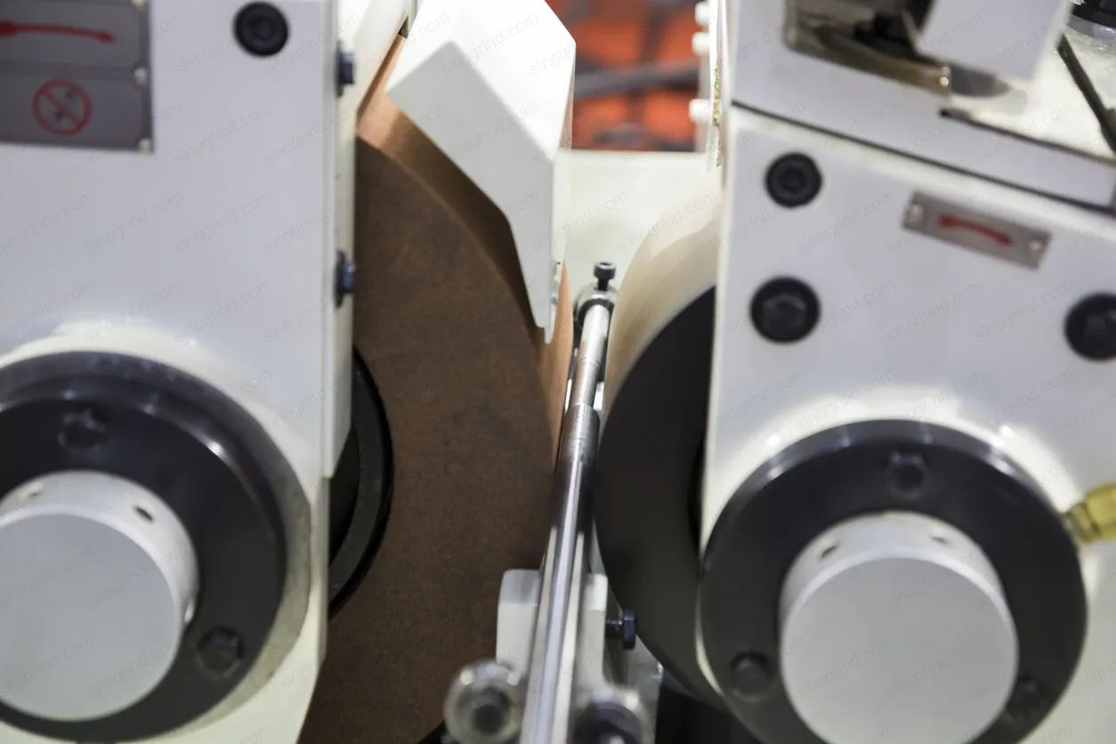 Centerless grinding setup with grinding wheel, regulating wheel, and work rest blade